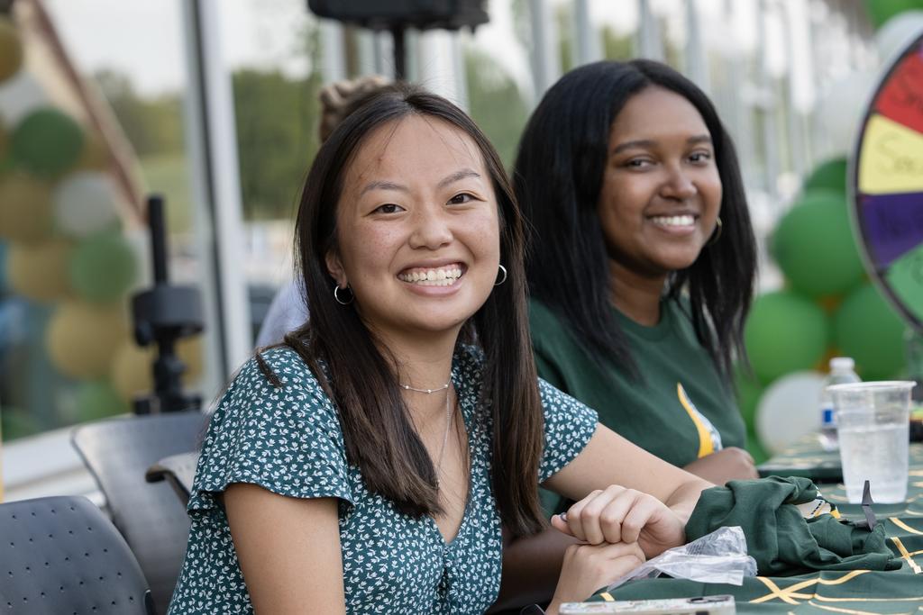 Two graduate students sitting at a table at the Beacon Hall welcome.