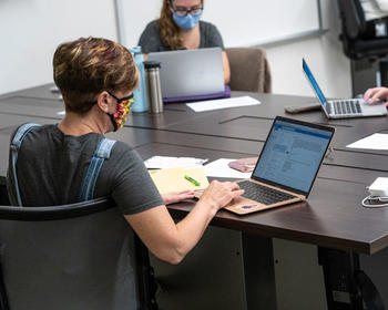 Social work graduate students work on laptops in the hybrid learning classroom in Peterson Hall, Fairfax Campus, GMU